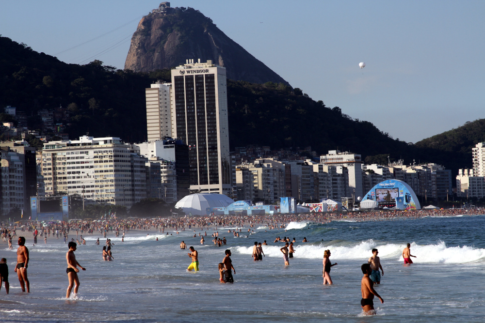 Crowds enjoying mindfulness exercises at Copacabana beach in Rio de Janeiro, finding presence in walking, swimming, and relaxing by the ocean. Enjoying mindfulness exercises – people walking, swimming, and relaxing at Copacabana beach in Rio de Janeiro.
