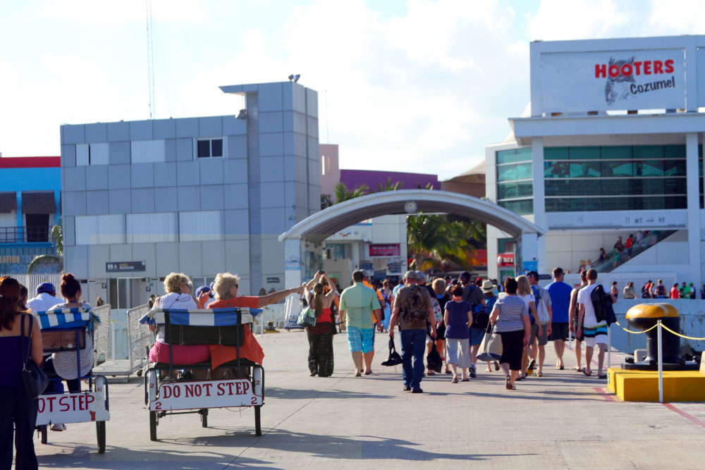 Cruise passengers walking from the pier toward shops and restaurants in Cozumel, symbolizing movement and flow for a List of Somatic Exercises focused on daily activity.