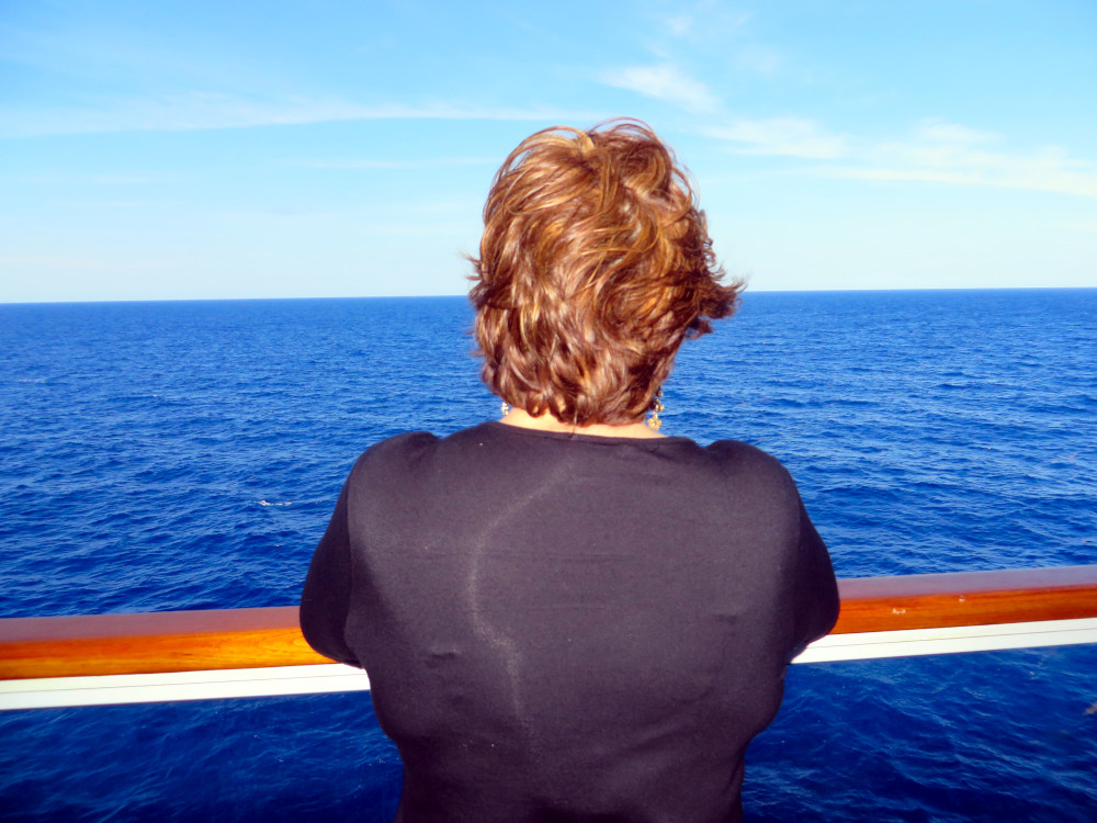 What is Somatic Experiencing? A calming, body-based approach to trauma healing, reflected in the Maria's image looking at the ocean and finding steadiness within What is Somatic Experiencing shown through Maria gazing at the open sea, symbolizing reflection, nervous system settling, and gentle healing through body awareness.